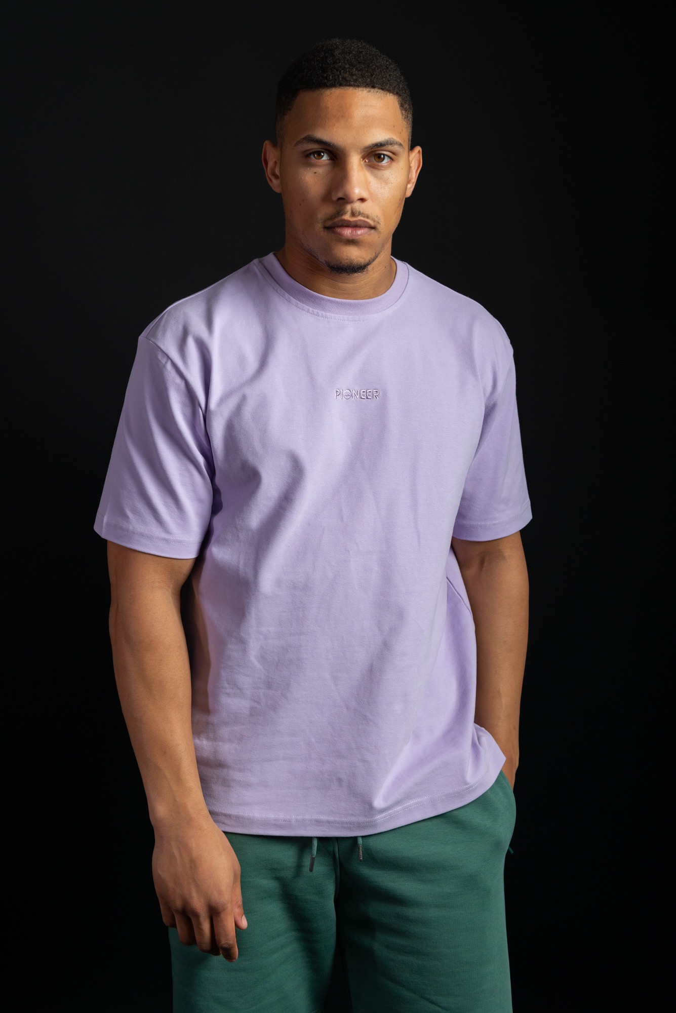 Model in lavender Pioneer London T-shirt and teal sweatpants