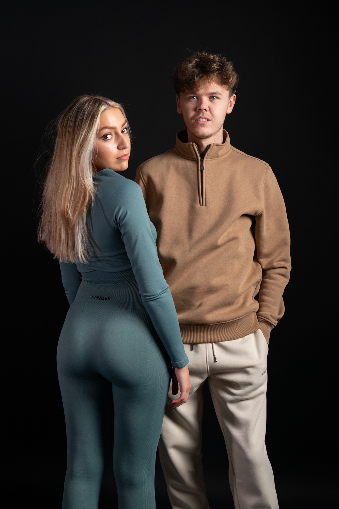 Pioneer 410 Sweats fashion campaign featuring two models in contemporary sportswear against a dark studio background